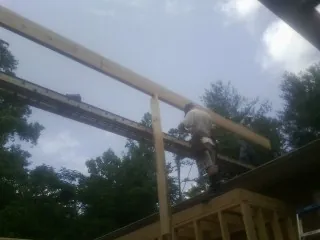 Carpenter setting a ridge beam over a new addition frame — Ice Dam Removal by Roofing Brothers in Bloomsburg