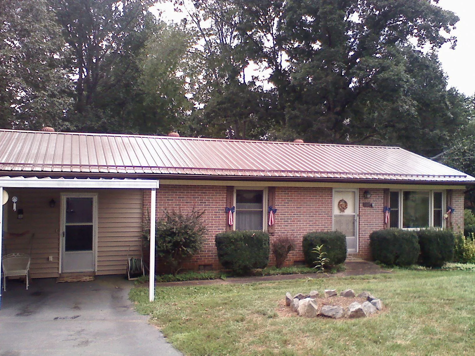 Bronze metal roof and carport on a brick ranch home — Roof Repair work by our crew in Bloomsburg